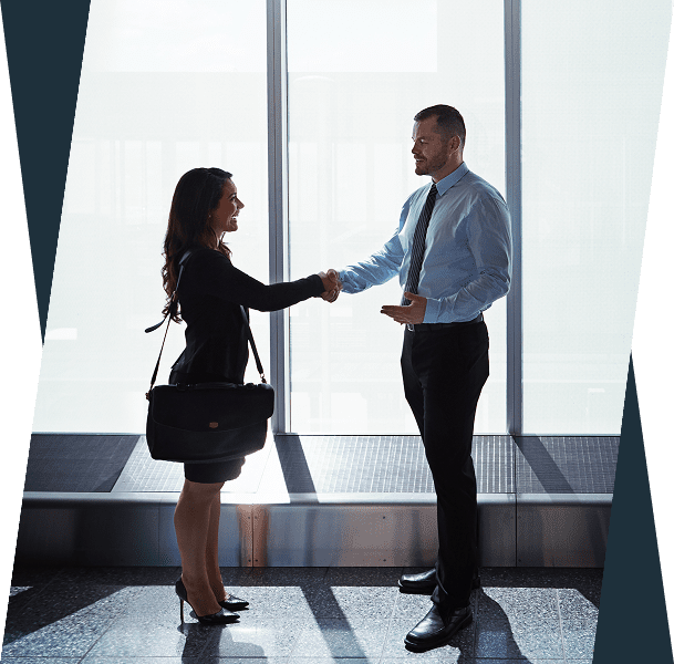 Two people shaking hands near window.