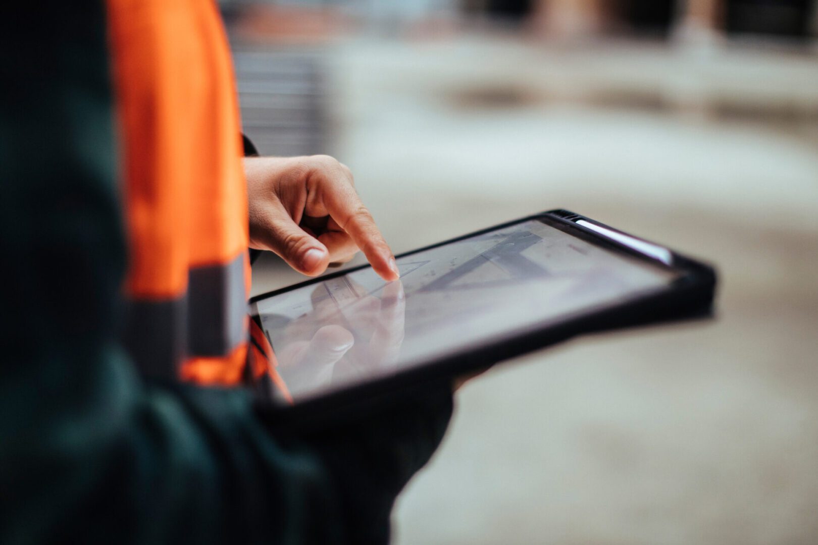 Person using tablet in construction setting.