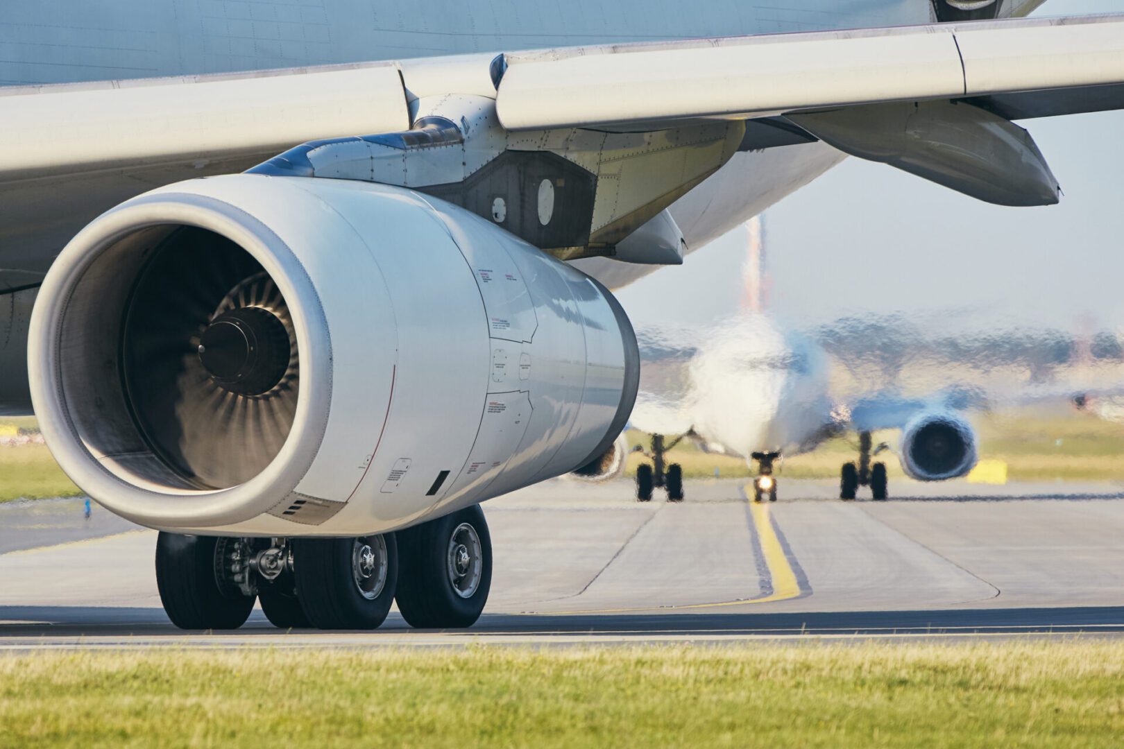 Airplane taxiing on runway, close-up view.